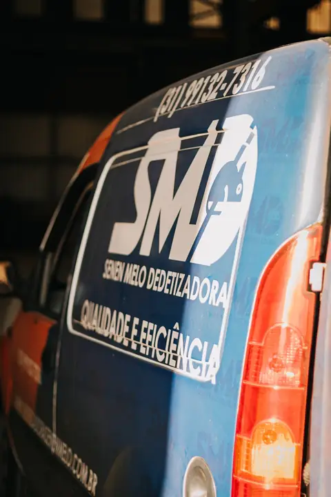 Lateral do veículo azul e laranja da Senen Melo, com o logotipo SMD, o telefone e a frase “Qualidade e eficiência”.