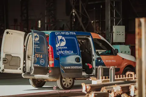 Veículo da Senen Melo com as portas traseiras abertas, estacionado em um galpão.