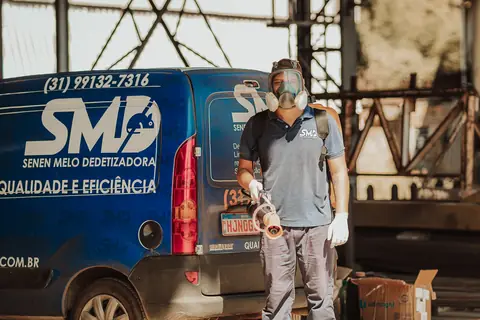 Profissional com máscara facial e equipamento portátil em frente ao veículo da Senen Melo.